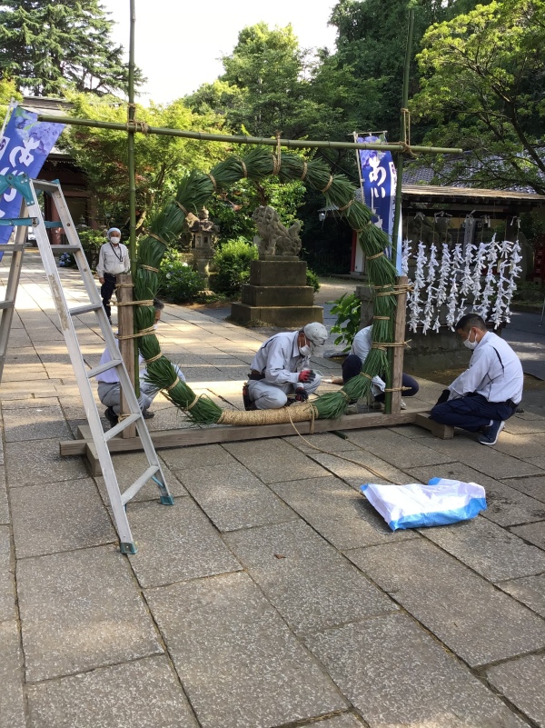 茅の輪の設置中　茅の葉を編んで輪っかにしている